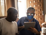 A medical professional meeting with a person in his home.