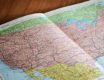 A paper map of the United States on a table.